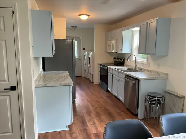 a kitchen with a sink a refrigerator a stove a washer and dryer