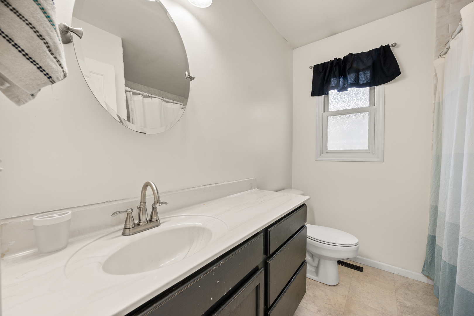 323 West Church Street Genoa, IL 60135 - Photo 14 of 28 a bathroom with a sink toilet a mirror and vanity