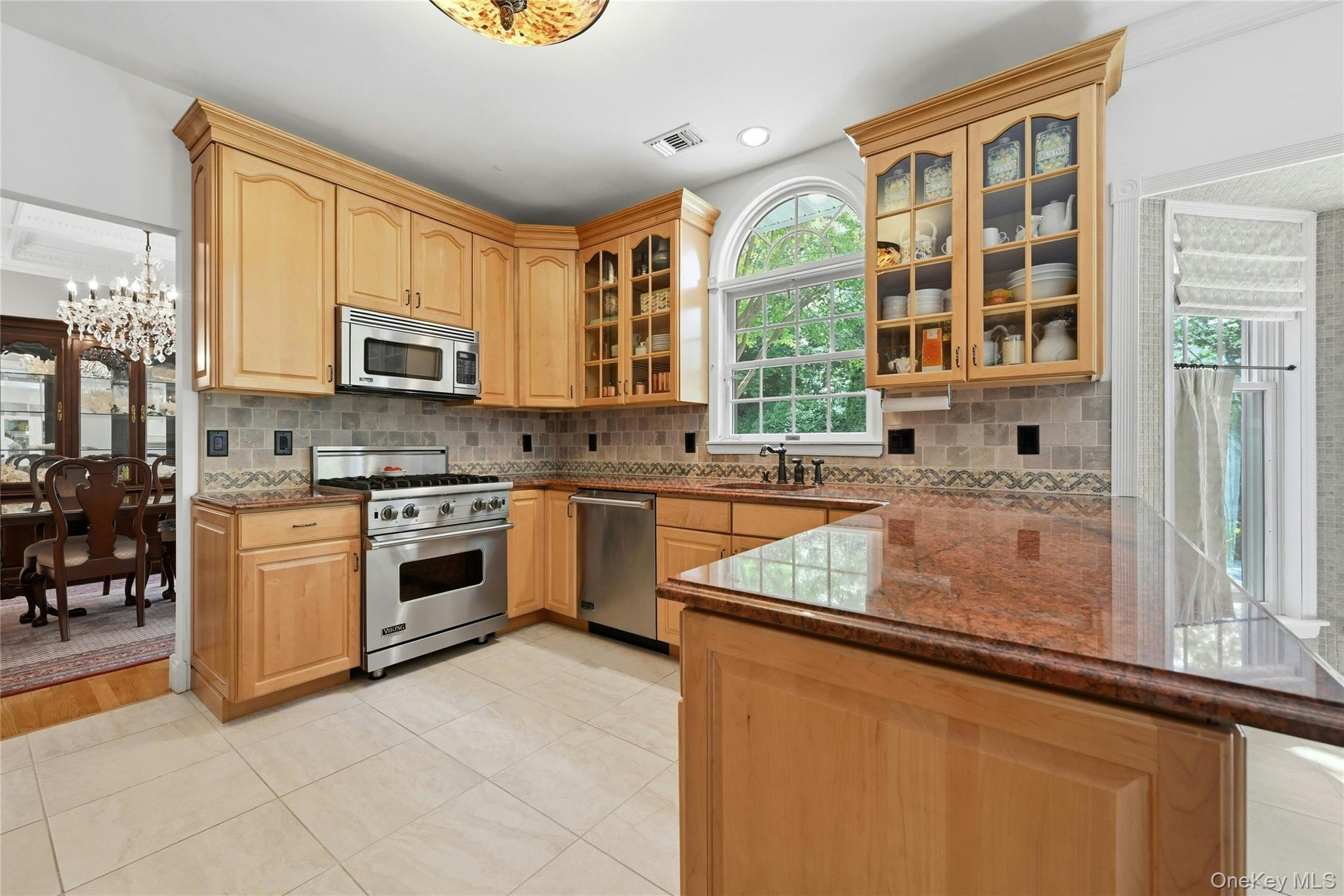 6 Thunder Road Miller Place, NY 11764 - Photo 18 of 50 The Spectacular Three Year Old Chef's Kitchen Offers Walls Of Extra Height Custom Maple Cabinetry With Beautiful Moldings, Detailwork & Trims, Glass Doors, Premium Granite Countertops With Expansive Counter/Serving Areas, Tiled Backsplash With Accent Border, Stunning Circle Topped Window Over The Sink, A Suite Of Viking Stainless Steel Appliances (Including A Gas Range), Porcelain Tiled Floors & A Large Dinette Area Which Opens Into The Family Room/Den.