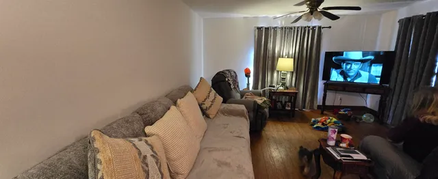 a living room with furniture a flat screen tv and a fireplace