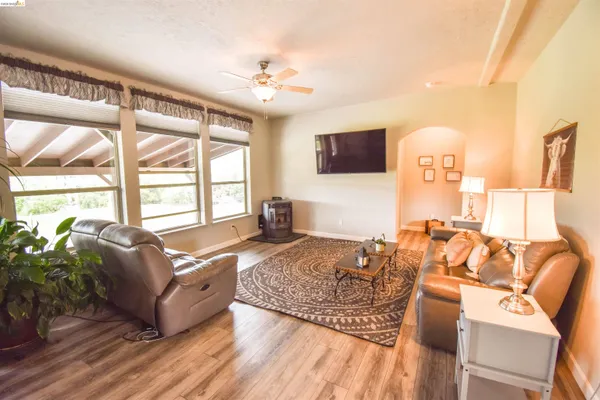 a living room with furniture a flat screen tv and a large window
