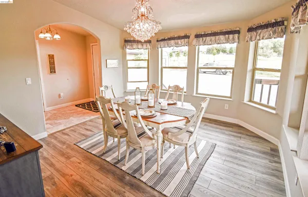 a view of a dining room with furniture a chandelier and wooden floor
