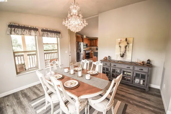 a view of a dining room with furniture a chandelier and wooden floor