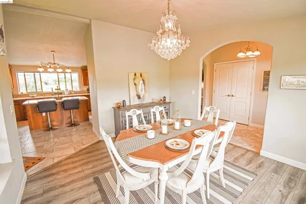a view of a dining room with furniture a chandelier and wooden floor