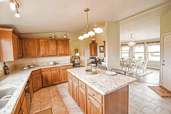 a large kitchen with kitchen island granite countertop a large center island attached withe living room