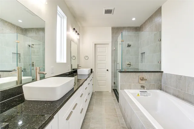 a bathroom with a granite countertop tub sink and mirror