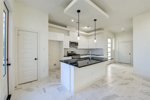 a kitchen with stainless steel appliances granite countertop a stove and a refrigerator