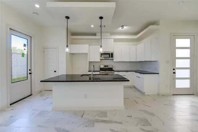 a kitchen with stainless steel appliances granite countertop a sink and a stove