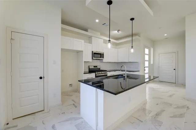 a kitchen with kitchen island a sink stainless steel appliances and a counter top