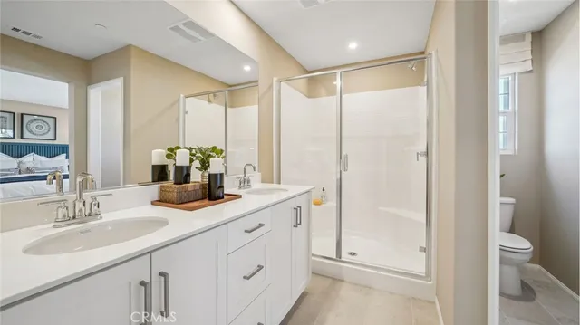 a bathroom with a double vanity sink and mirror with shower