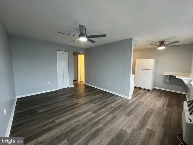 a view of a livingroom with wooden floor and a ceiling fan