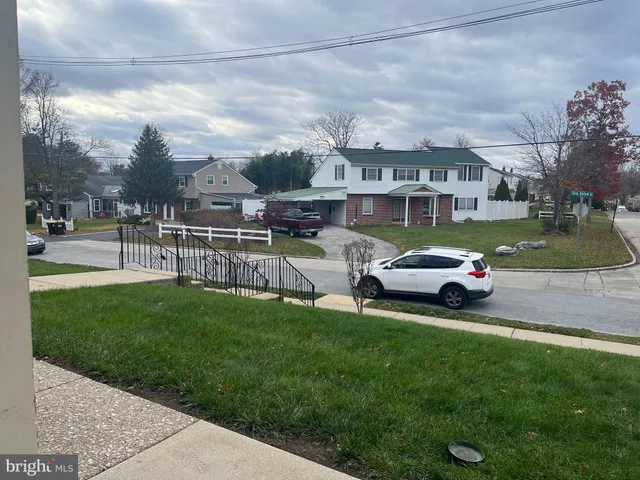 a car parked in front of a house and a yard