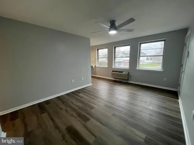 a kitchen with a refrigerator a stove top oven a sink and wooden floor