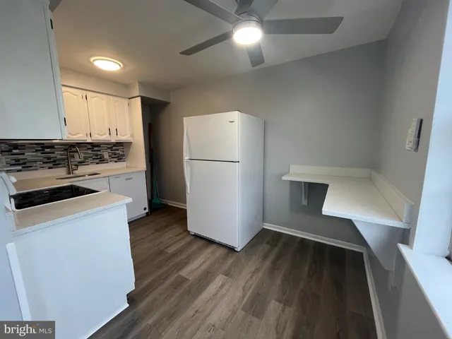 a kitchen with granite countertop white cabinets and white appliances