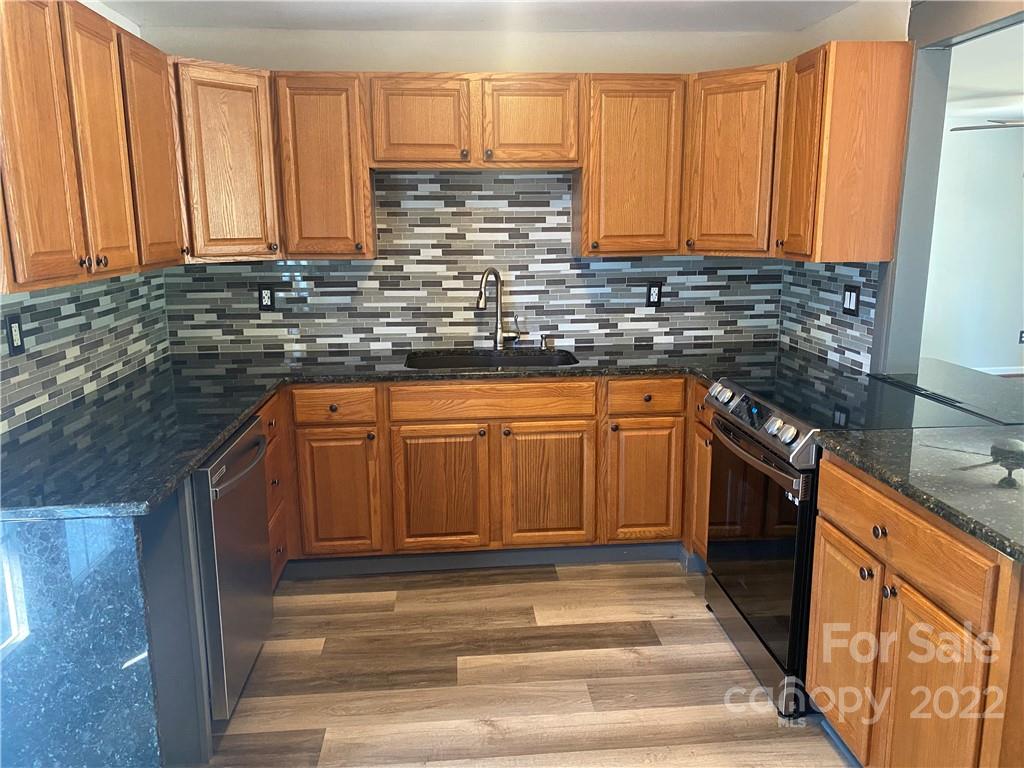 1911 Beacon Road Lancaster, SC 29720 - Photo 5 of 19 a kitchen with stainless steel appliances granite countertop a stove a sink dishwasher and a microwave oven with wooden cabinets