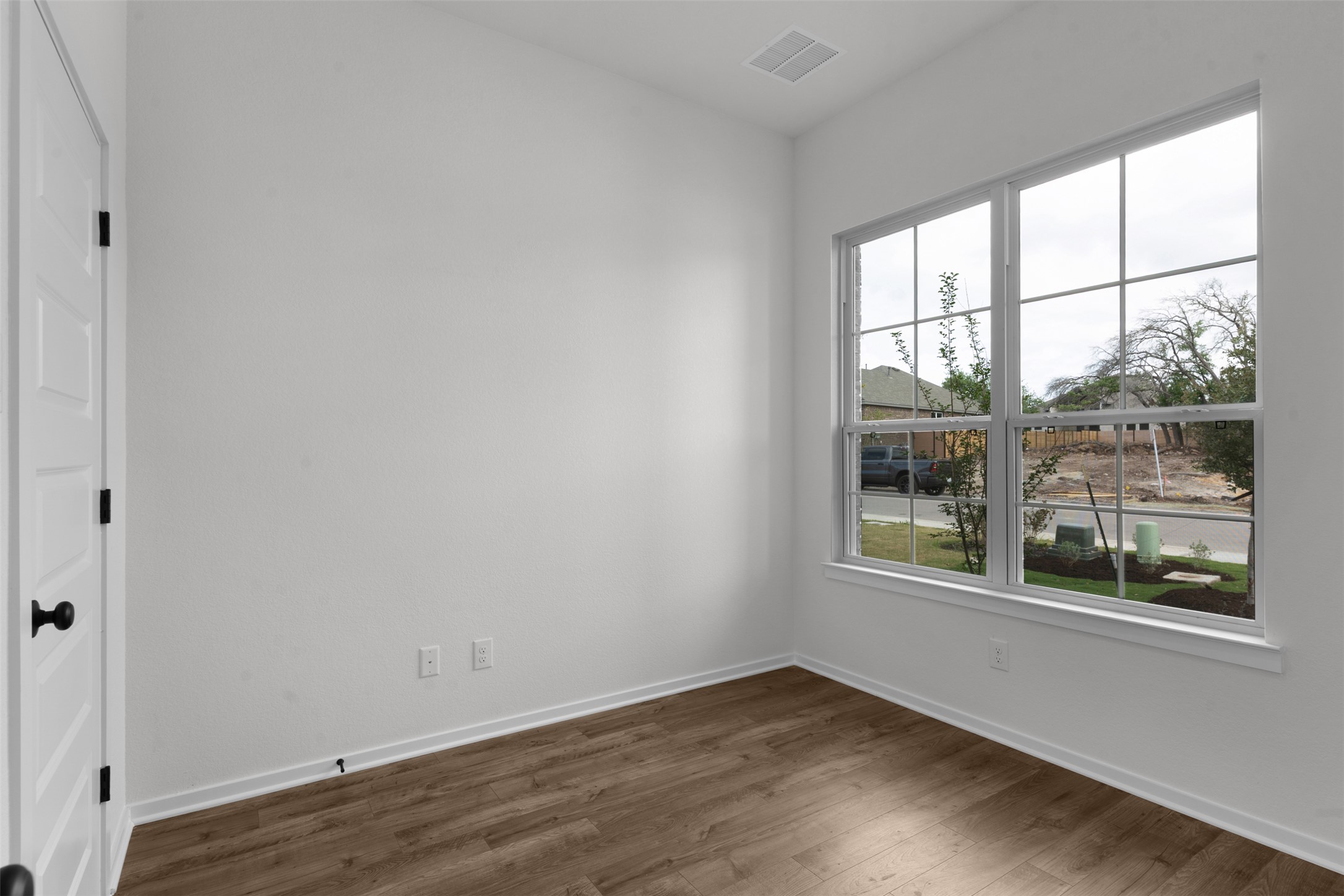 405 Raleigh Drive Georgetown, TX 78633 - Photo 4 of 27 Empty room featuring dark wood-type flooring and baseboards
