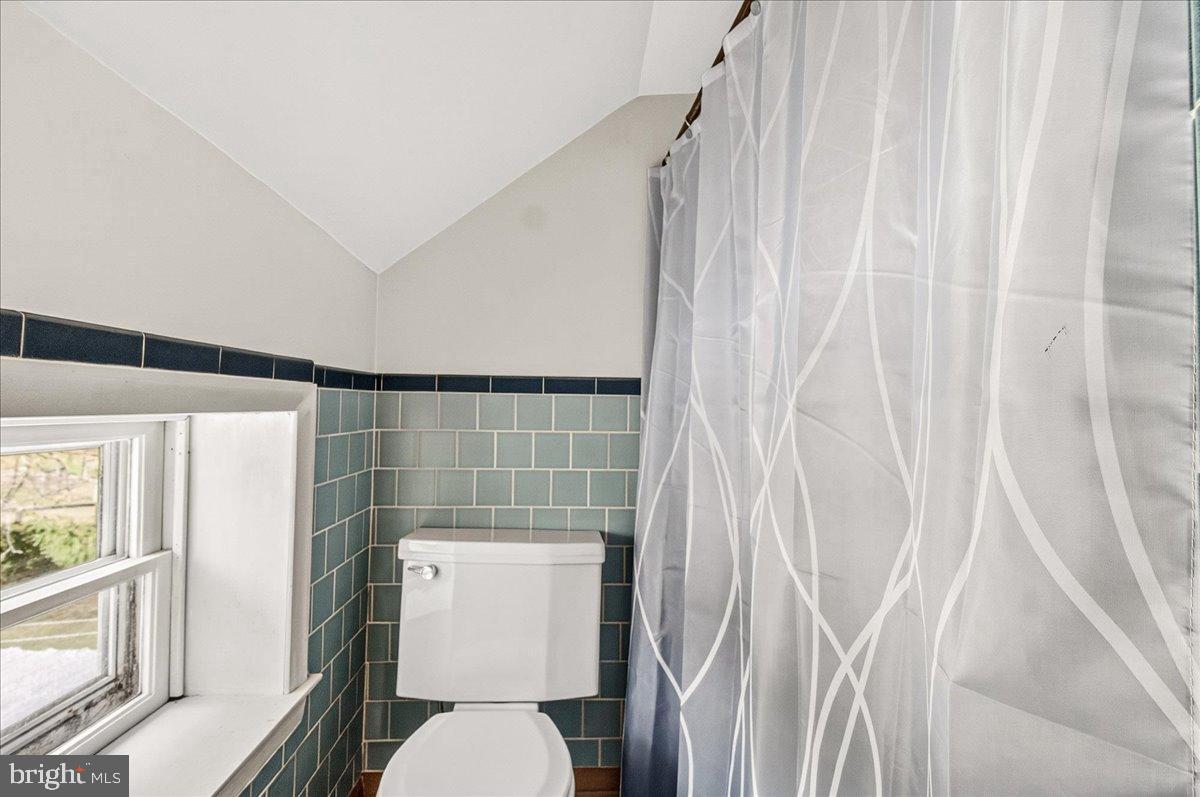 11804 Pleasant Walk Road Myersville, MD 21773 - Photo 29 of 49 a white toilet sitting next to a shower curtain