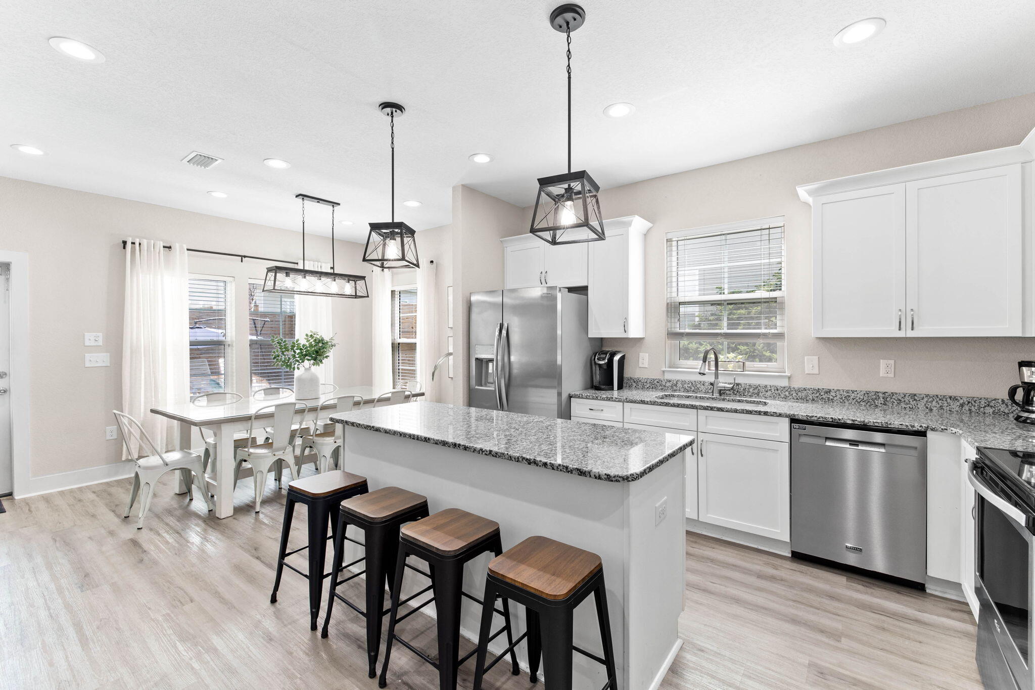 22 Mobile Street Miramar Beach, FL 32550 - Photo 16 of 55 a kitchen with stainless steel appliances granite countertop a stove a refrigerator a kitchen island a dining table and chairs with wooden floor