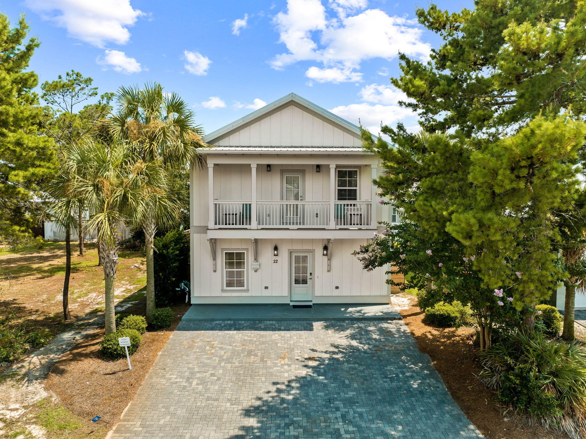 22 Mobile Street Miramar Beach, FL 32550 - Photo 51 of 55 a view of a white house next to a yard with big trees and plants