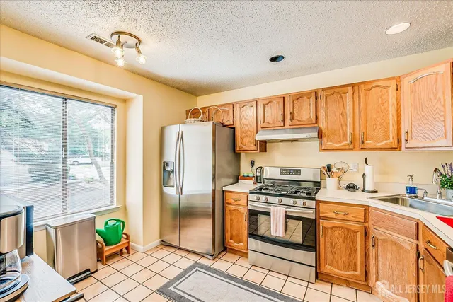 a kitchen with stainless steel appliances a stove a sink and a refrigerator