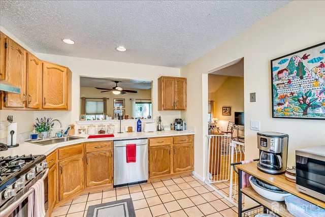 a living room with stainless steel appliances kitchen island granite countertop a sink and cabinets