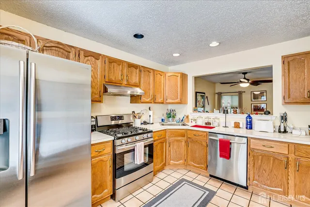 a kitchen with stainless steel appliances sink stove refrigerator and cabinets