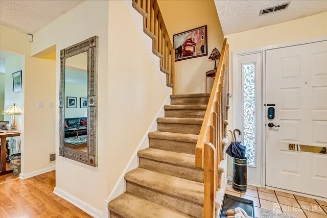 a view of entryway and hall with wooden floor
