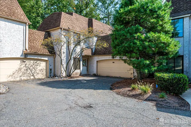 a view of a white house next to a road and yard