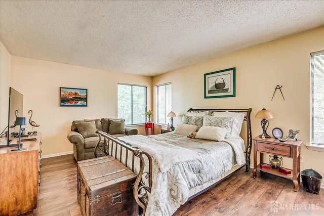 a spacious bedroom with a bed a couch and a dresser next to a window