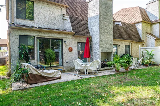 a view of house with backyard and outdoor seating