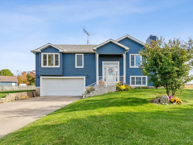a front view of a house with a yard and trees