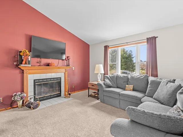 a living room with furniture a flat screen tv and a fireplace