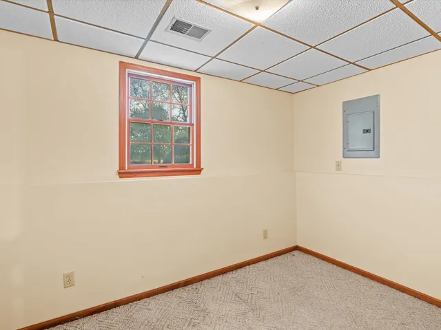 a view of a big room with a window and a ceiling fan