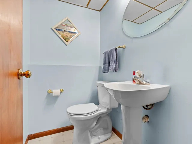 a bathroom with a sink a toilet and a mirror