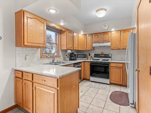 a kitchen with stainless steel appliances granite countertop a stove a sink and a refrigerator