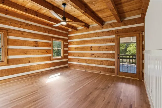 a view of room with wooden floor and windows