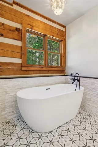 a white bath tub sitting in a bathroom next to a window
