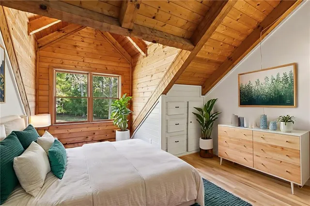 a bedroom with a bed and large windows