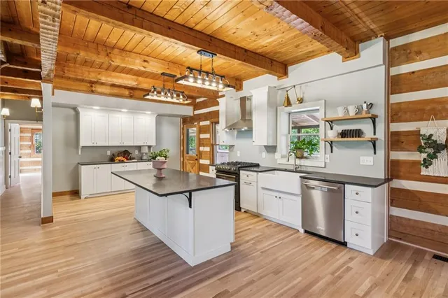 a kitchen with stainless steel appliances granite countertop wooden floors and white cabinets