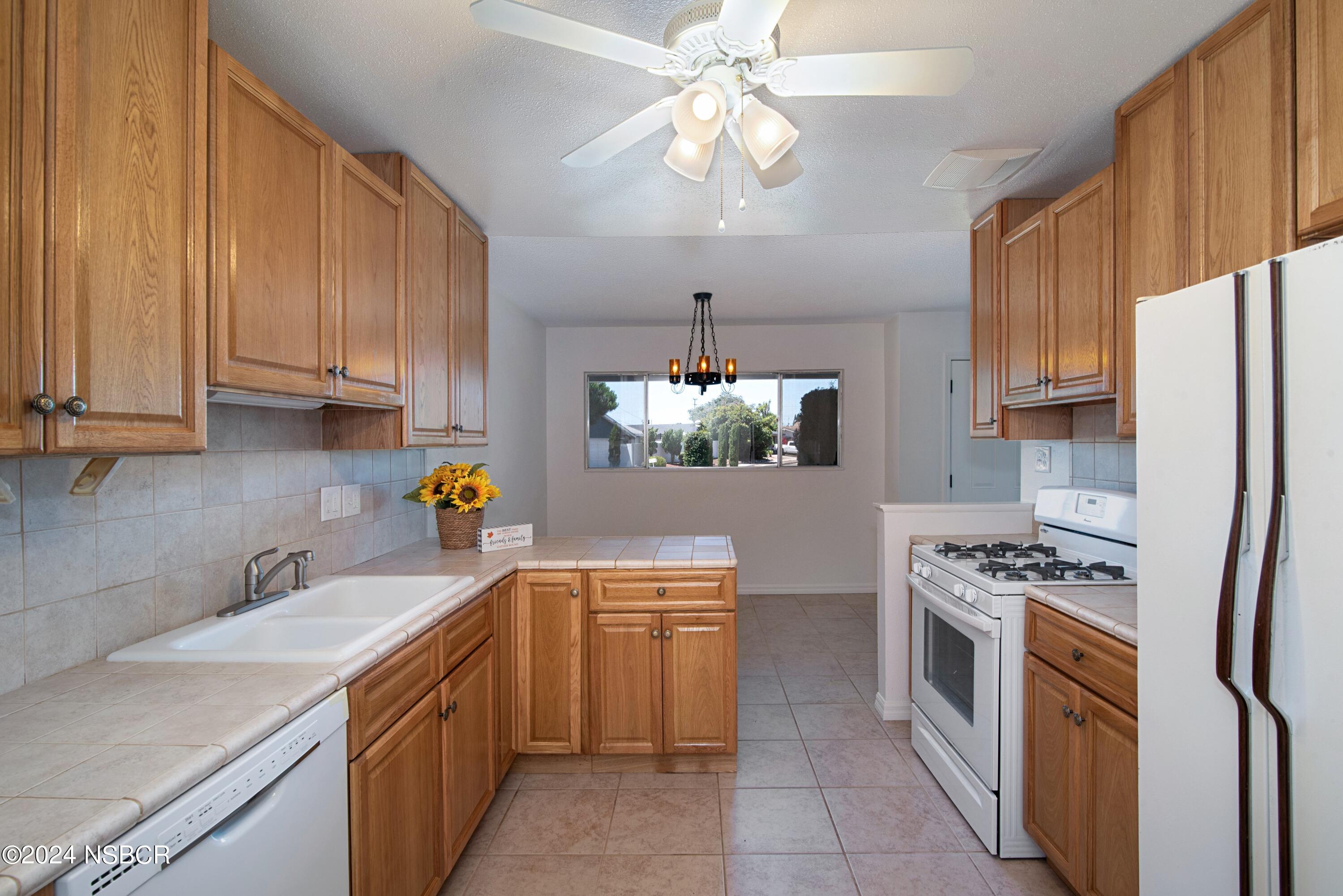 3380 Via Elba Lompoc, CA 93436 - Photo 6 of 23 a kitchen with stainless steel appliances a sink a stove a refrigerator cabinets and a window