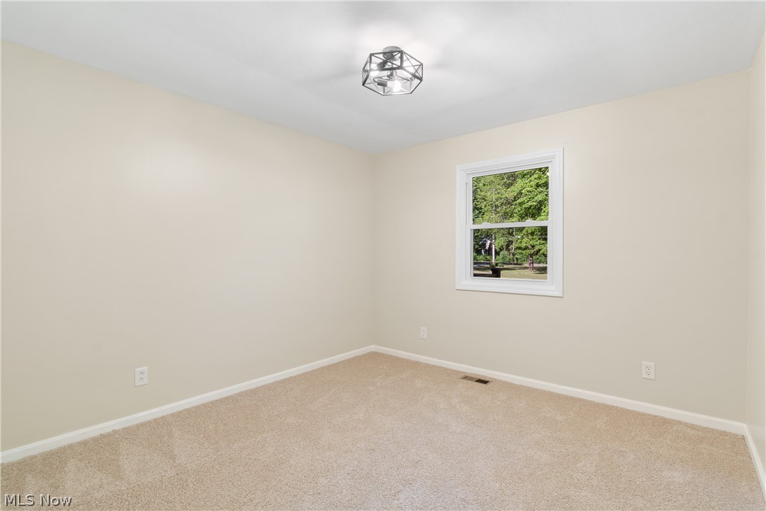 1075 Northeast River Road Lake Milton, OH 44429 - Photo 21 of 34 Cream-painted interior with neutral carpeting and white baseboards