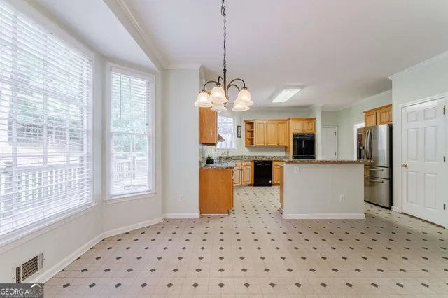 a kitchen with stainless steel appliances granite countertop a refrigerator a sink and wooden cabinets