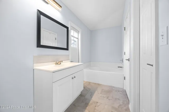 a bathroom with a sink a mirror and a bathtub