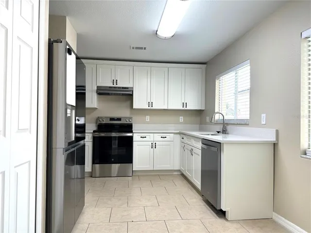 a kitchen with a stove top oven and sink