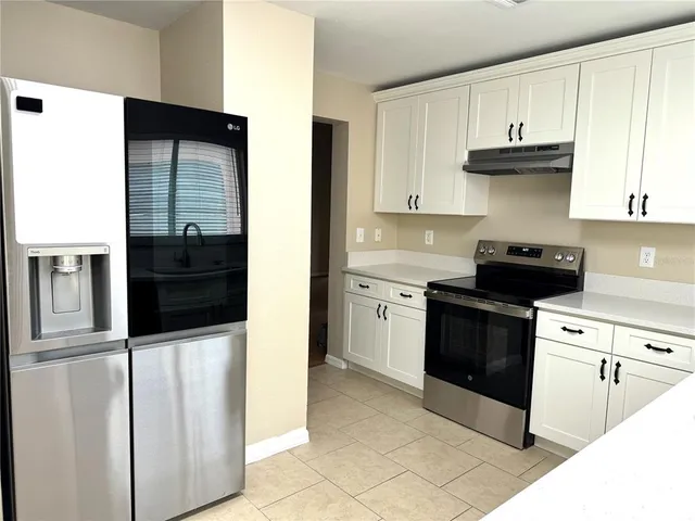 a kitchen with stainless steel appliances granite countertop a refrigerator and a stove