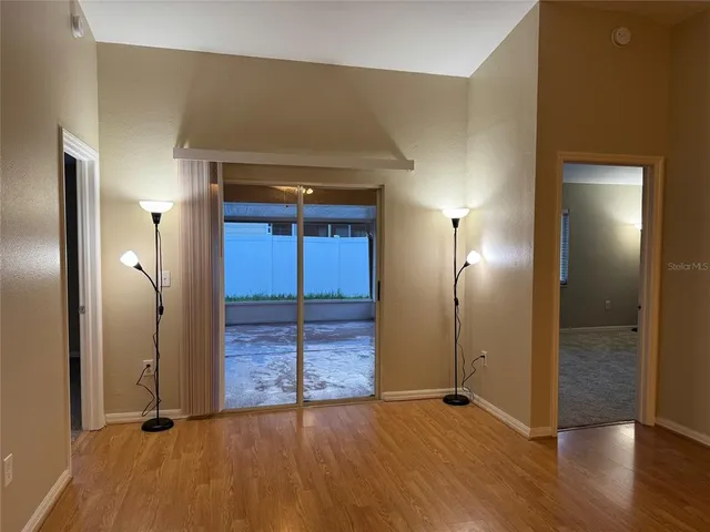 an empty room with wooden floor and mirror