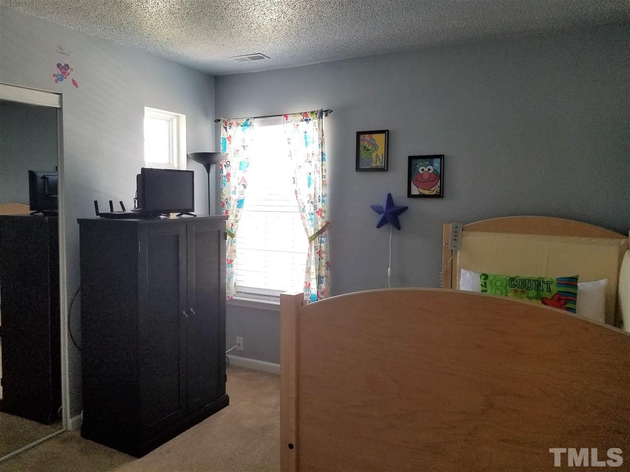 5832 Ricker Road Raleigh, NC 27610 - Photo 11 of 14 a bedroom with a bed and furniture
