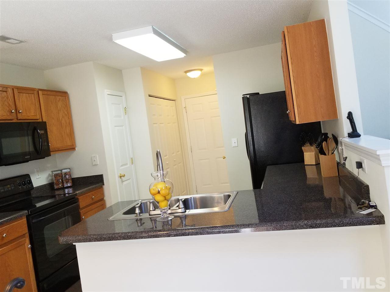 5832 Ricker Road Raleigh, NC 27610 - Photo 5 of 14 a kitchen with stainless steel appliances granite countertop a sink stove and refrigerator