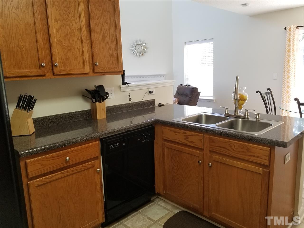 5832 Ricker Road Raleigh, NC 27610 - Photo 6 of 14 a kitchen with granite countertop a sink cabinets and stainless steel appliances