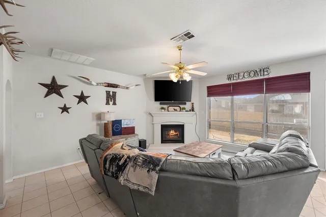 a living room with furniture a fireplace and a flat screen tv